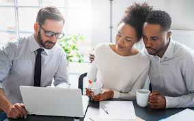 couple meeting with insurance agent looking at computer