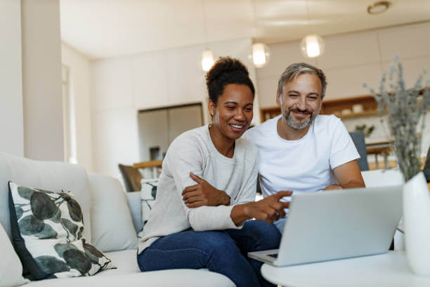 Happy couple reading a blog on their laptop